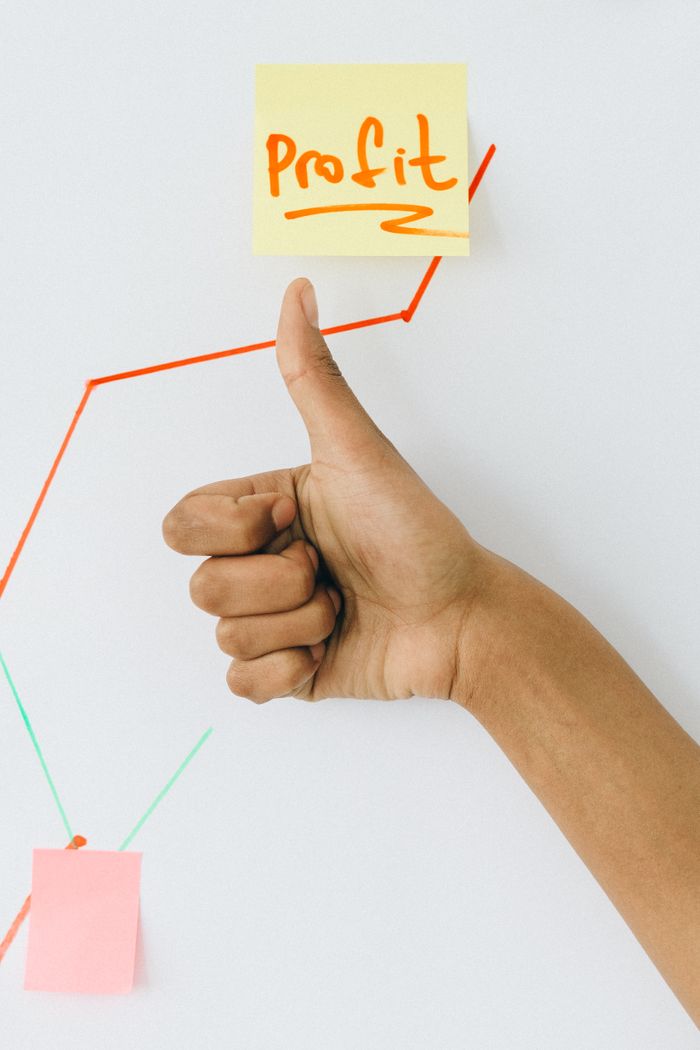 Services A hand giving a thumbs up in front of a profit growth chart, highlighting success.